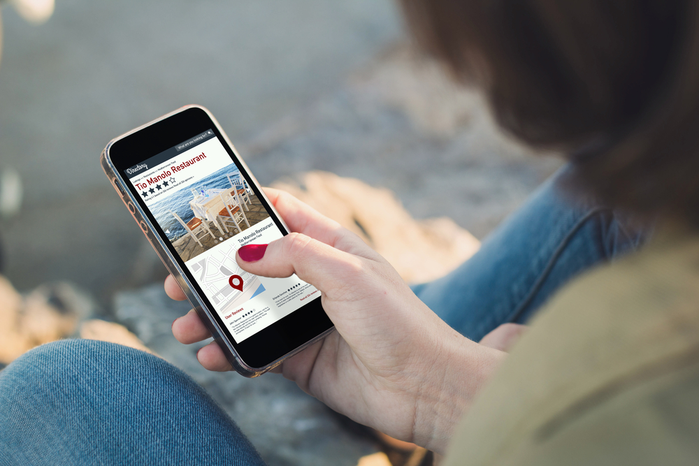 woman holding a phone looking into a directory