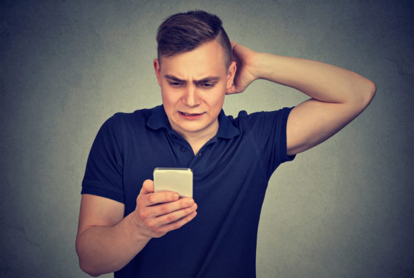 confused man looking at his phone